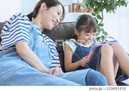 ソファで笑い合う母と娘の幸せなひととき ソファで笑い合う母と娘の幸せなひととき 129091910