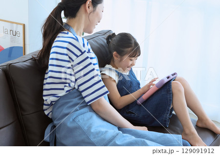 ソファで笑い合う母と娘の幸せなひととき 129091912