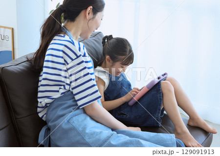 ソファで笑い合う母と娘の幸せなひととき 129091913