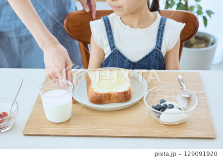 親子で迎える朝の食卓、パンとヨーグルトの健康的な朝食 親子で迎える朝の食卓、パンとヨーグルトの健康的な朝食 129091920