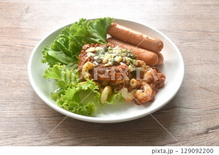 steamed macaroni dressing fried chop pork and slice tomato in ketchup sauce with sausage couple lettuce on plate steamed macaroni dressing fried chop pork and slice tomato in ketchup sauce with sausage couple lettuce on plate 129092200