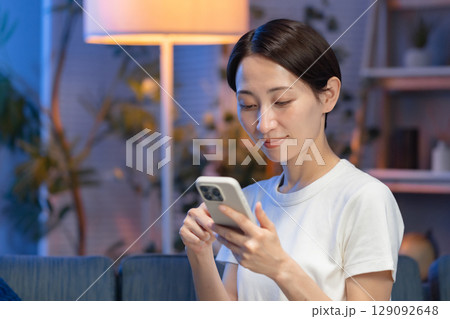 夜にスマホを持つ女性 夜にスマホを持つ女性 129092648