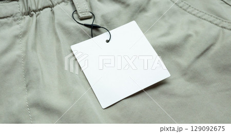 Blank white clothes tag label on gray fabric texture background Blank white clothes tag label on gray fabric texture background 129092675
