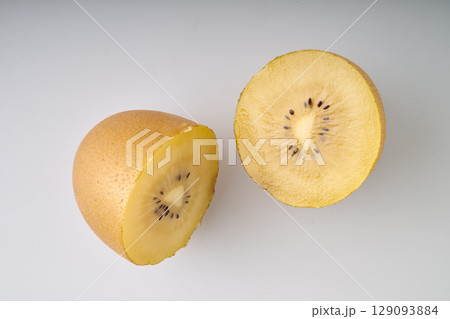 Half slices of yellow kiwi on whithe background 129093884