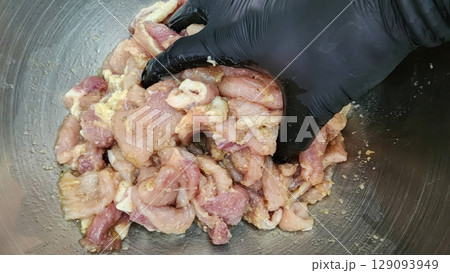 Preparing Meat for Cooking in a Stainless Steel Bowl 129093949