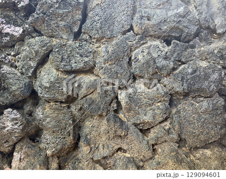 Hard black lava stone rock wall background 129094601
