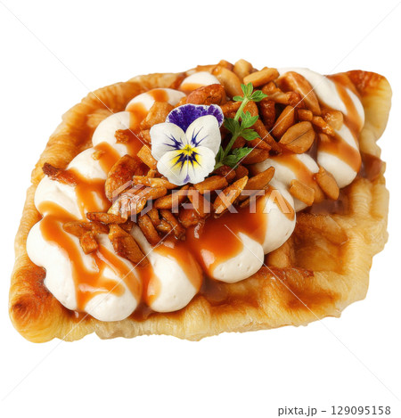 Delicious croffle topped with whipped cream, caramel sauce, nuts, and edible flower creates delightful treat 129095158