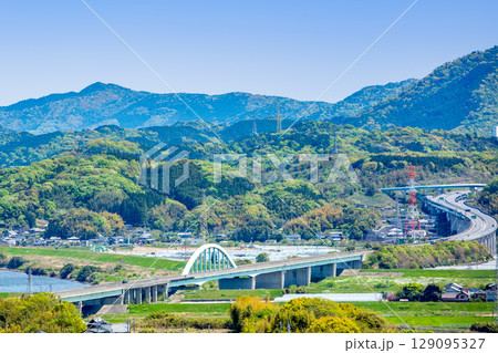 東九州道の大野川橋付近と新緑の山並み 129095327