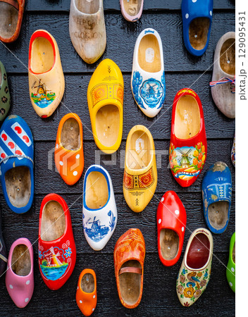 Colorful wooden clogs on dark wooden panels Colorful wooden clogs on dark wooden panels 129095431