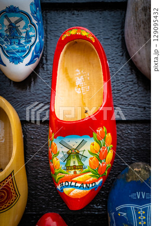 Wooden shoes painted with different regional motifs. Wooden clogs, typical traditional footwear from the Netherlands. Wooden shoes painted with different regional motifs. Wooden clogs, typical traditional footwear from the Netherlands. 129095432