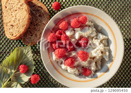Ricotta or cottage cheese with fresh raspberries. 129095450