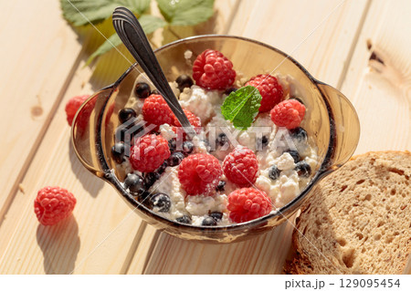 Cottage cheese with fresh raspberries and  blueberries. 129095454