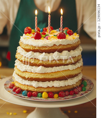 Birthday cake with colorful candles and candies close-up Birthday cake with colorful candles and candies close-up 129096134