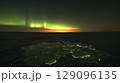 Stunning aurora borealis lighting up the dark night sky above a frozen lake, creating a magical and serene winter landscape 129096135