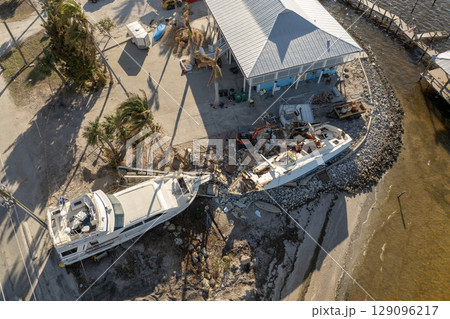 Capsized sunken sailing boat left forsaken on shallow bay waters after hurricane Milton in Englewood, Florida 129096217