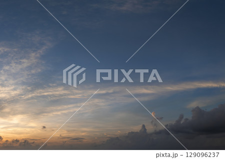 Bright colorful orange and yellow clouds on horizon. Beautiful sunset sky scenery 129096237