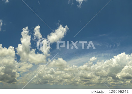 Blue sky with white summer rain clouds. Colorful summer landscape Blue sky with white summer rain clouds. Colorful summer landscape 129096241