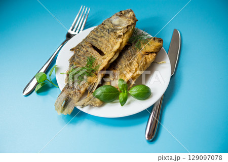 Homemade dish - golden crucian carp on a plate with spices 129097078