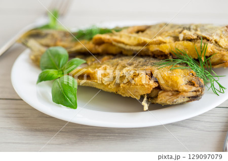Traditional Ukrainian fried crucian carp in a village kitchen 129097079