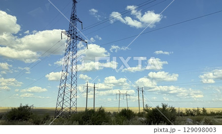 Many high-voltage transmission tower and electricity pylon power lines against blue sky with cloud 129098003