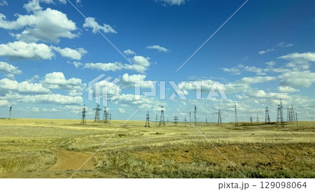 Many high-voltage transmission tower and electricity pylon power lines against blue sky with cloud Many high-voltage transmission tower and electricity pylon power lines against blue sky with cloud 129098064
