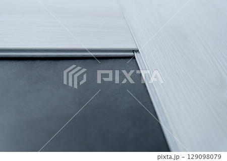 A man lays a quartz laminate on the floor. Renovation, Installation of French herringbone 129098079