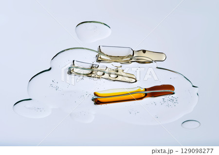 Three ampoules in a drop of cosmetic preparation. Three ampoules in a drop of cosmetic preparation. 129098277