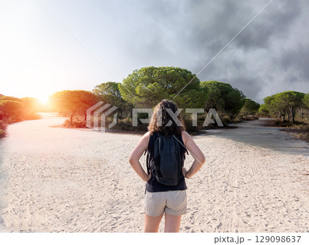 Woman choosing a path in a forest. Concept of decision making in life. Woman choosing a path in a forest. Concept of decision making in life. 129098637