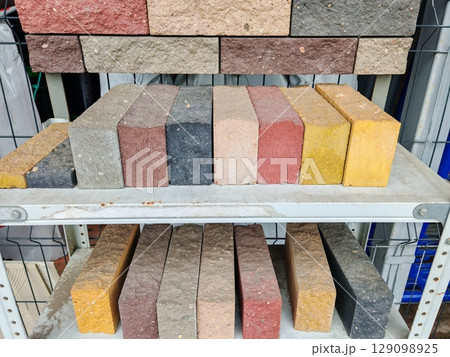 Close up view of a stack of bricks displaying various shades of red and gray. bricks show texture and subtle variations in color. At hardware store. 129098925
