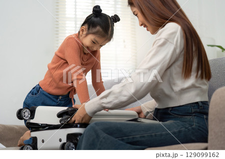 Family Travel. Child and mother packing a suitcase together at home. Family Travel. Child and mother packing a suitcase together at home. 129099162