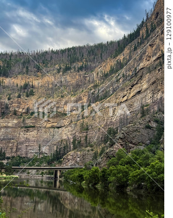 Towering Canyon Cliffs Overlooking a Serene River Valley 129100977