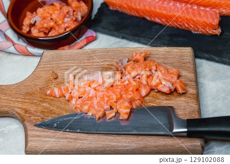 Raw Salmon Being Chopped for Fish Patties Raw Salmon Being Chopped for Fish Patties 129102088