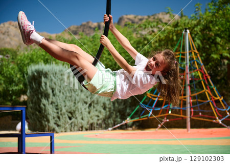 Happy Child Enjoying Playground Adventures on a Bright Summer Day 129102303