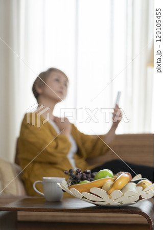ソファーに座りスマホを手にする高齢女性 ソファーに座りスマホを手にする高齢女性 129105455