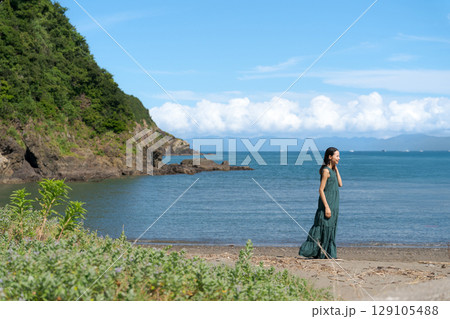 砂浜を歩く若い女性 129105488