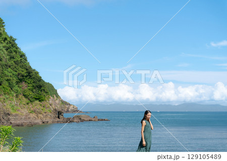 砂浜を歩く若い女性 129105489