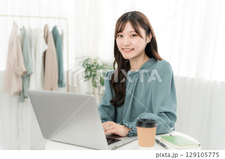 オフィス・仕事場でパソコンを使う若いアジア人ビジネスウーマン オフィス・仕事場でパソコンを使う若いアジア人ビジネスウーマン 129105775
