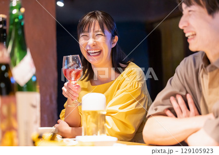 居酒屋でお酒を飲んでる男女 129105923