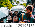 夏の日差しが強い日に傘をさして歩く人々 129107432