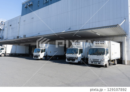 物流倉庫の積み下ろし場とトラック4台 物流倉庫の積み下ろし場とトラック4台 129107892