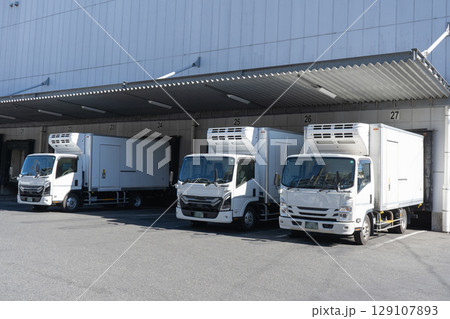 物流倉庫の積み下ろし場とトラック3台 物流倉庫の積み下ろし場とトラック3台 129107893