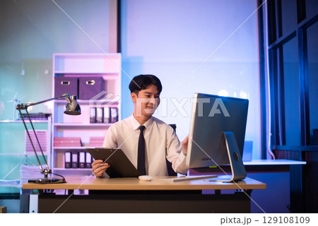 Businessman drinking coffee to get some energy for working overtime sitting at desk using computer and doing overtime Businessman drinking coffee to get some energy for working overtime sitting at desk using computer and doing overtime 129108109