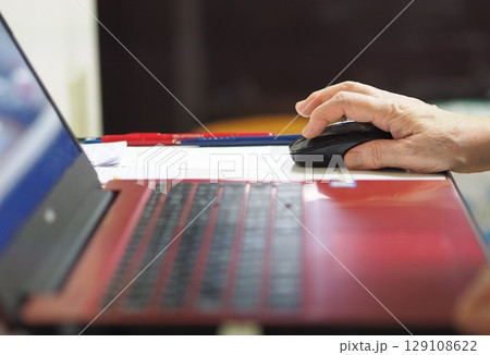 マウスを操作する高齢女性の手元 129108622