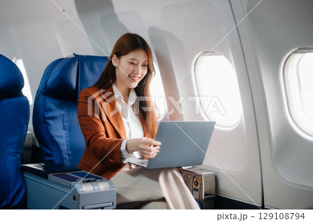 Asian woman sitting in a seat in airplane and looking out the window going on a trip vacation travel concept.Capture the allure 129108794