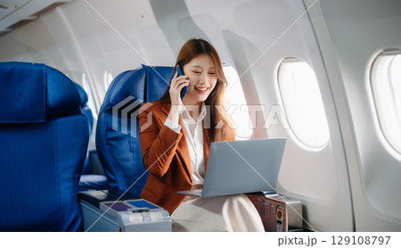 Asian woman sitting in a seat in airplane and looking out the window going on a trip vacation travel concept.Capture the allure Asian woman sitting in a seat in airplane and looking out the window going on a trip vacation travel concept.Capture the allure 129108797