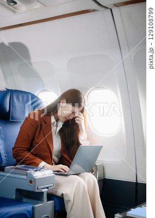 Asian woman sitting in a seat in airplane and looking out the window going on a trip vacation travel concept.Capture the allure 129108799