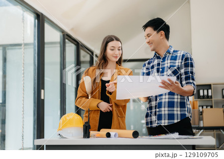 Engineer teams meeting working together wear worker helmets hardhat with on architectural project site and making model house. 129109705