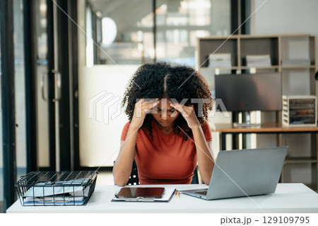 Business woman is stressed, bored, and overthinking from working on a tablet at office. Business woman is stressed, bored, and overthinking from working on a tablet at office. 129109795