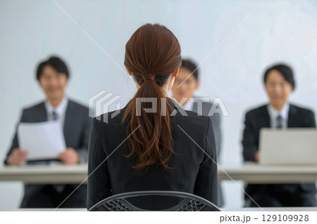 企業の採用シーン、女性応募者が多様な面接官の前に座る 129109928