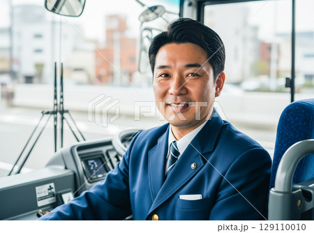 運転席で笑顔で写るベテランのバス運転手 129110010